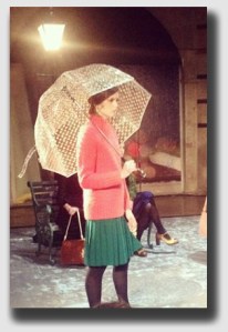 She's walking down the hall carrying a wet umbrella. Might it be raining outside?